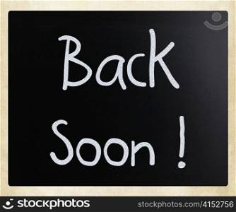 ""Back soon!" handwritten with white chalk on a blackboard"