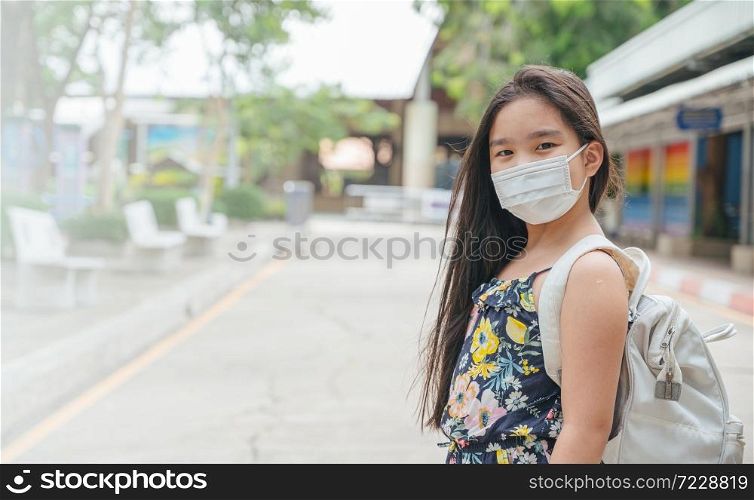 Back to school. asian child girl wearing face mask with backpack going to school .Covid-19 coronavirus pandemic.New normal lifestyle.Education concept.