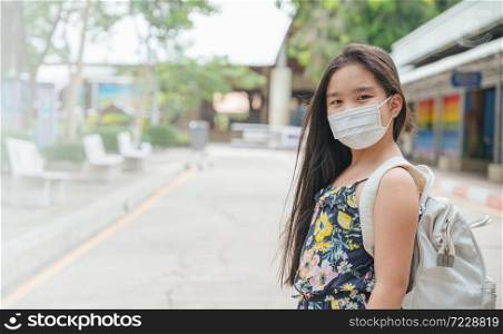 Back to school. asian child girl wearing face mask with backpack going to school .Covid-19 coronavirus pandemic.New normal lifestyle.Education concept.