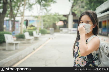 Back to school. asian child girl wearing face mask with backpack  going to school .Covid-19 coronavirus pandemic.New normal lifestyle.Education concept.