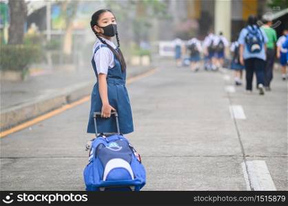 Back To School. Asian children girl wear mask to protection for coronavirus(covid-19) in the school . Portrait of Thai student wearing protection mask bad weathe. infection control concept.
