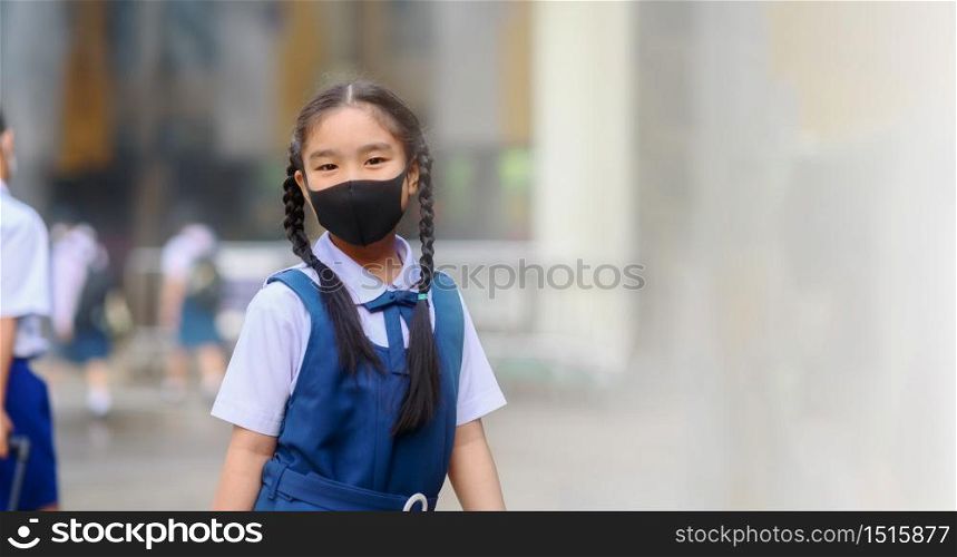 Back To School. Asian children girl wear mask to protection in prevention for coronavirus(covid-19) in the school . Portrait of Thai student wearing protection mask bad weathe. Protection against virus and infection control concept.