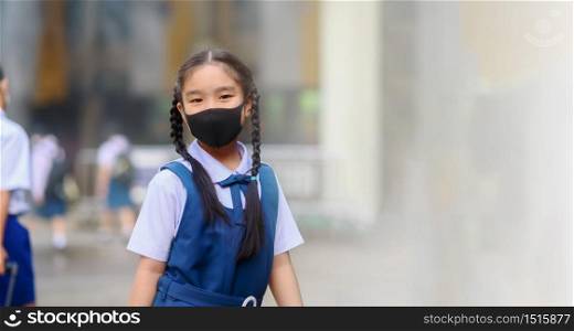 Back To School. Asian children girl wear mask to protection in prevention for coronavirus(covid-19) in the school . Portrait of Thai student wearing protection mask bad weathe. Protection against virus and infection control concept.