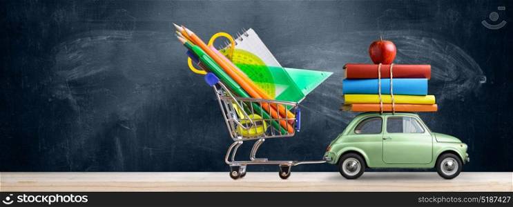Back to school car.. Back to school sale background. Car delivering shopping cart with accessories, books and apple against blackboard.