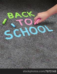 Back to school chalk drawing with blank area for copy space on a concrete sidewalk with the hand of a child holding a color as a symbol of education and the start of the school year for learning.