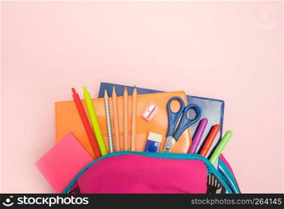 Back to school concept. Backpack with school supplies on colored background