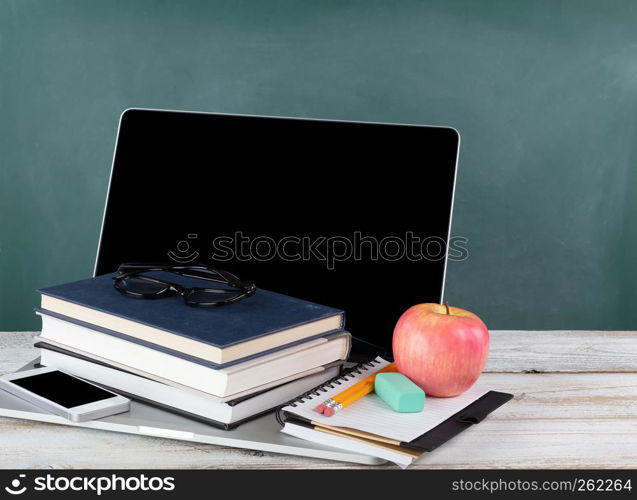 Back to school concept consisting of technology and traditional stationery with green chalkboard