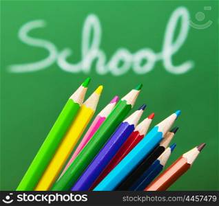 Back to school concept, green chalkboard with handwriting and set of colorful drawing pencils