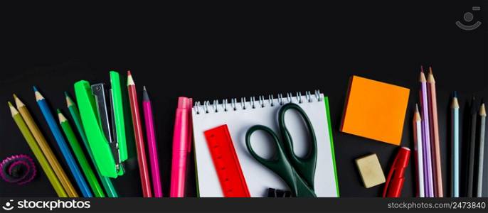Back to school concept. Office supplies on a chalkboard background. Place for text. Banner format. Back to school concept. Office supplies on chalkboard background. Banner format