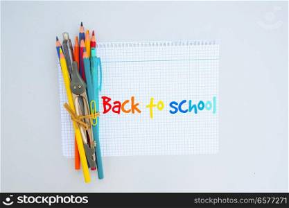 Back to school concept on blue - office supplies on ruled paper with copy space. back to school