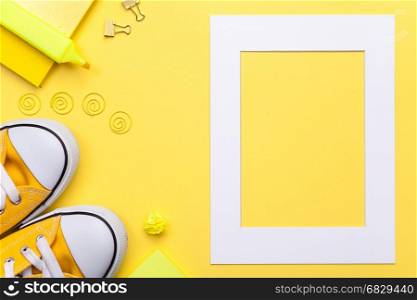 Back to school concept. School accessories with white frame on yellow background. Flat lay. Copy space. Top view