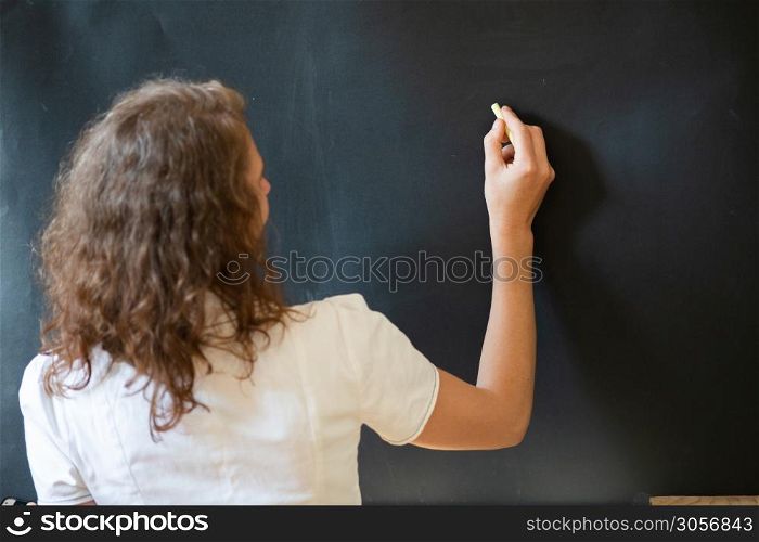 back to school concept teacher in front of chalkboard