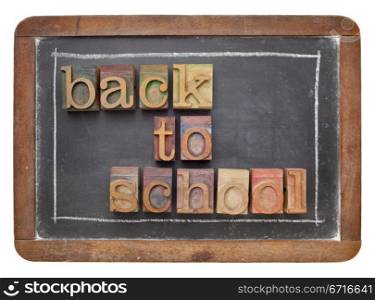 back to school concept - text in vintage letterpress wood type on a slate blackboard