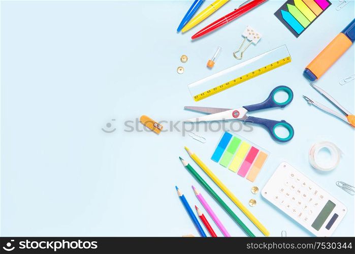 Back to school concept with colorful school supplies border on blue background with copy space, top view. back to school