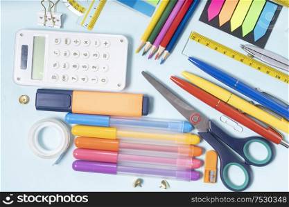 Back to school concept with colorful school supplies border on blue background, top view. back to school