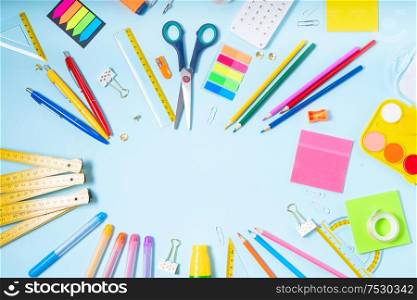 Back to school concept with colorful school supplies frame on blue background. back to school