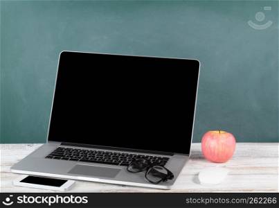 Back to school concept with modern wireless technologies and green chalkboard