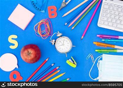 Back to school concept with school supplies and laptop on classic blue background. back to school