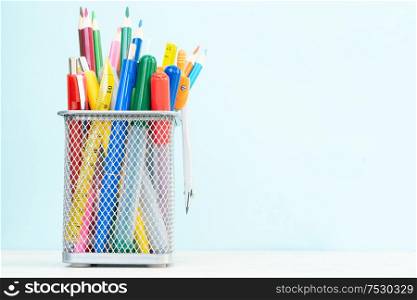 Back to school concept with school supplies on plain blue background with copy space. back to school
