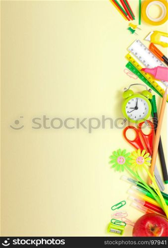 Back to School Conceptl: alarm clock, scissors, rulers, cutter, pencils, markers, paperclips, sharpener, scotch tape and red apple on the Yellow Background