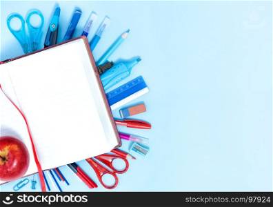 Back to School Conceptl: Notebook and School Supplies. Notebook, Bookmark, Pen, Pencils, Scissors, Felt Pens, Marker on the Blue Background. Backgroung in Blue, Red and White Colors.