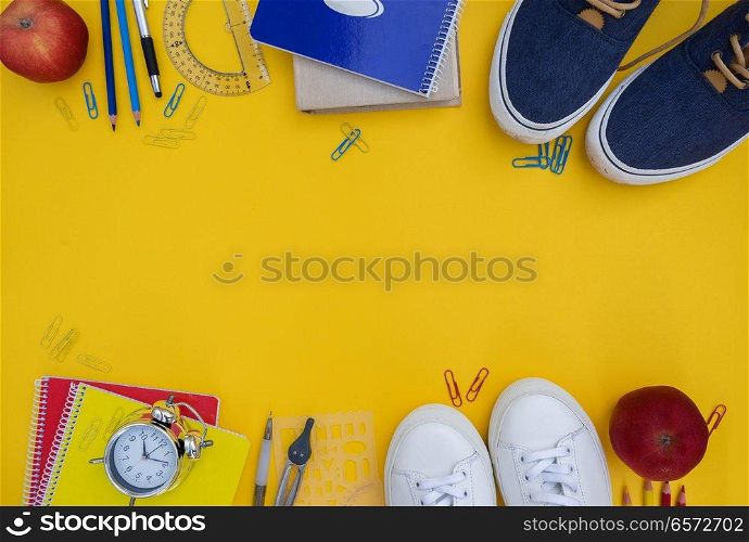 back to school frame- shoes with school supplies on yellow. back to school