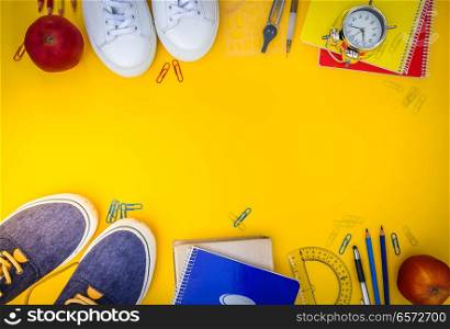 back to school frame- shoes with school supplies on yellow, retro toned. back to school