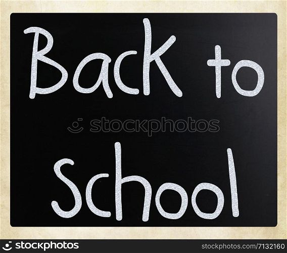 ""Back to school" handwritten with white chalk on a blackboard"