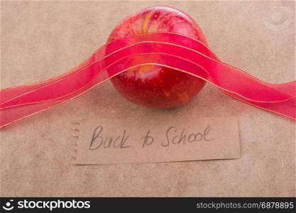 Back to school lettering with apple and a red ribbon