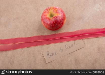 Back to school lettering with apple and a red ribbon