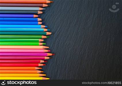 Back to school pencils color rainbow border on black board background. Back to school pencils