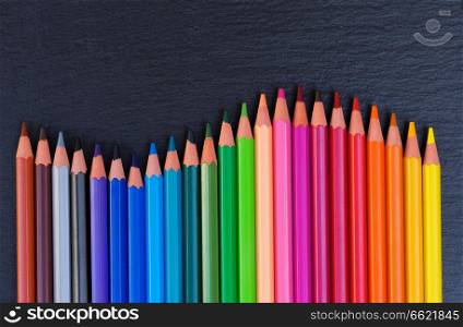 Back to school pencils rainbow border on black background. Back to school pencils