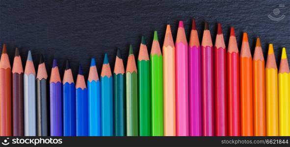Back to school pencils rainbow border on black board background. Back to school pencils