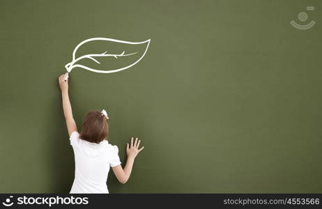 Back to school. Pretty girl of school age standing at blackboard