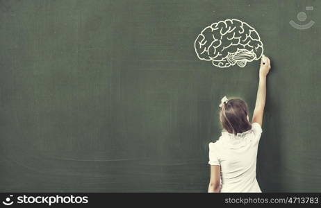 Back to school. Pretty girl of school age standing at blackboard