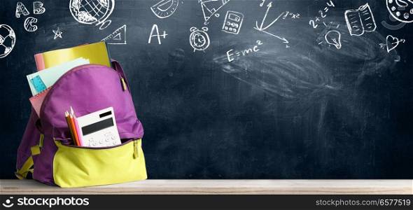 Back to school shopping backpack. Accessories in student bag against chalkboard. Back to school backpack.