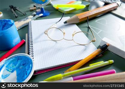 back to school still life on blackboard with teacher glasses pencil paint and several education stuff