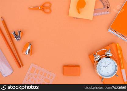 Back to school styled flat lay frame scene with school supplies on orange background. back to school