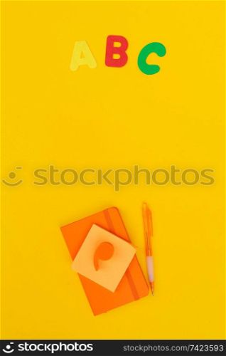 Back to school styled scene with abc and school supplies on yellow background. back to school