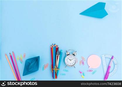 Back to school styled scene with school supplies and papercraft on blue background. back to school