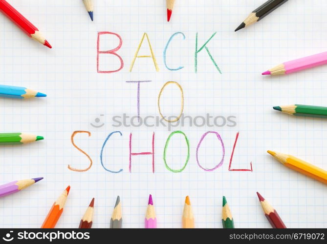 Back to school text on squared paper with colored pencils. Back To School