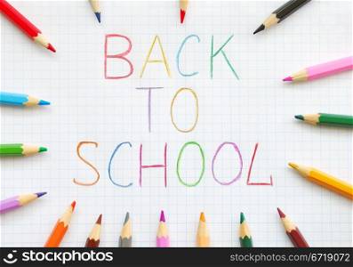 Back to school text on squared paper with colored pencils. Back To School
