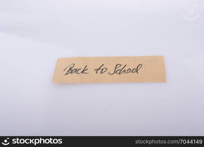 Back to school written on a note paper on white bakcground