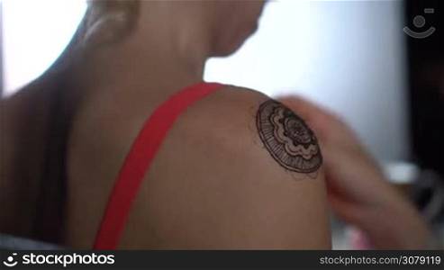 Back view closeup of woman&acute;s shoulder getting henna tattoo - video in slow motion