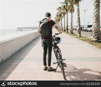 back view cyclist standing bicycle