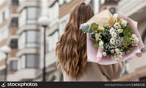 back view elegant woman holding bouquet flowers outdoors