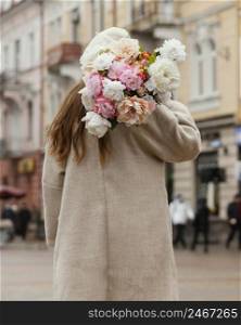 back view elegant woman outdoors holding bouquet flowers spring