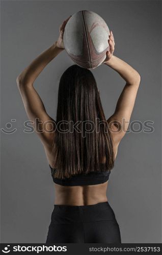 back view female rugby player posing with ball