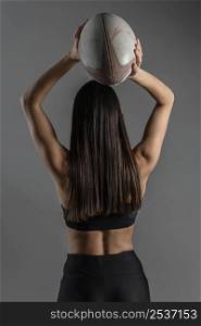 back view female rugby player posing with ball