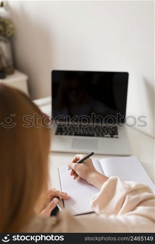 back view female teacher holding online class with laptop agenda